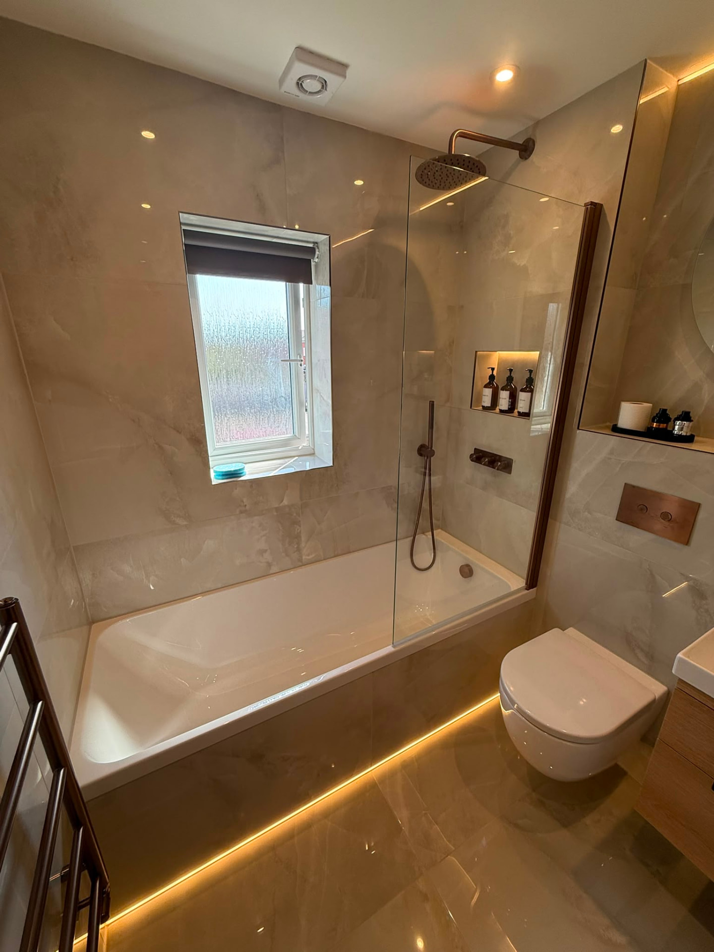 Bright Bathroom with LED Plinth & Bronze Towel Rail by DPS Plumbing & Bathrooms in Bramhall, Stockport