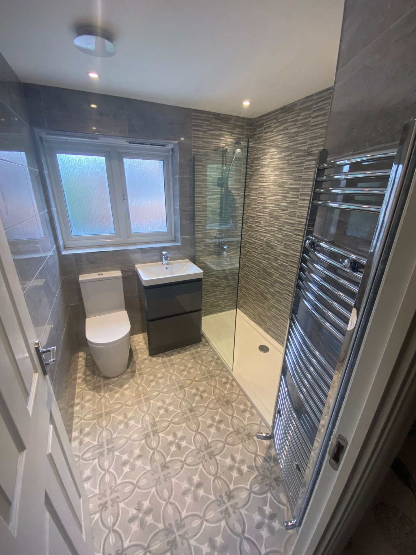 Bathroom renovation with patterned floor tiles and walk-in shower in Stockport