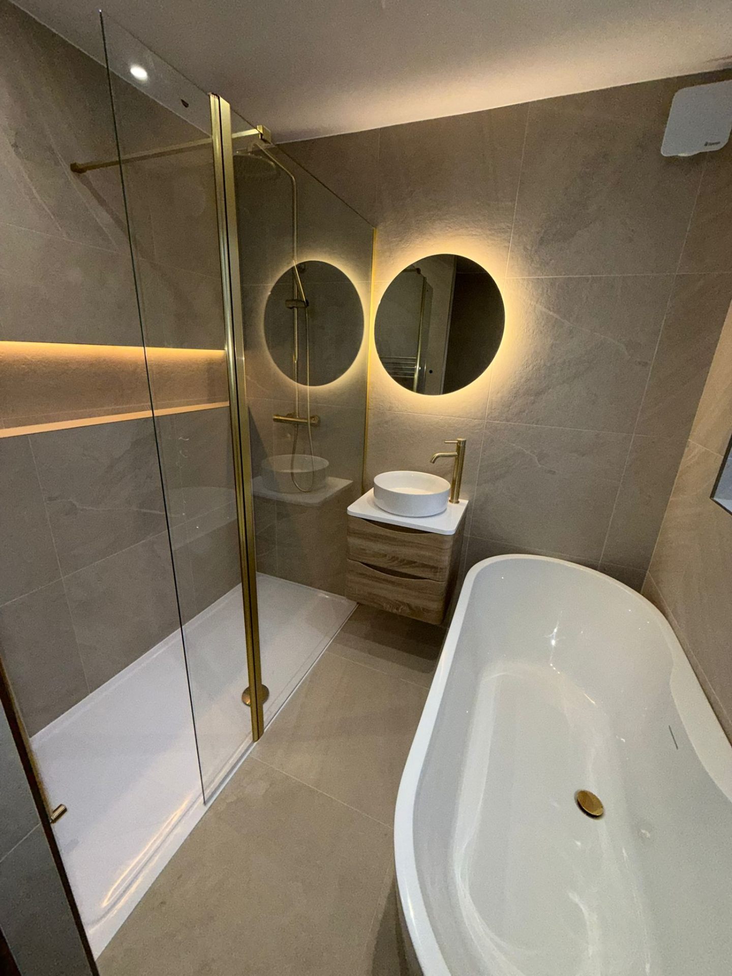 Luxury bathroom installation with gold fixtures, freestanding bath, and walk-in shower by DPS Plumbing Manchester