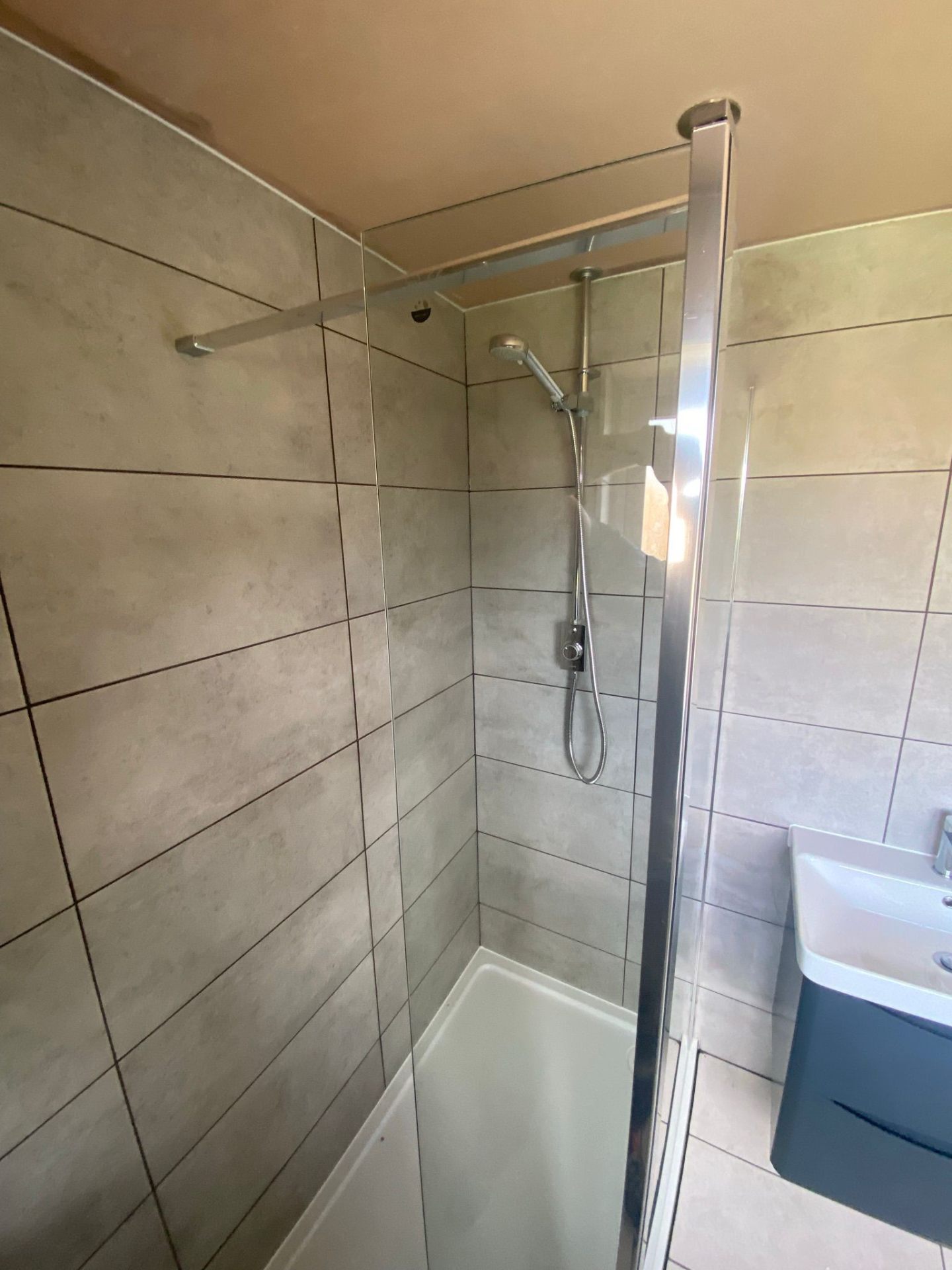 Glass shower enclosure with chrome fittings and vanity unit installed in Greater Manchester